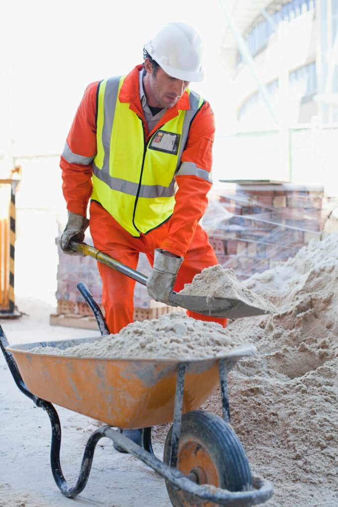 Worker shoveling concrete on site